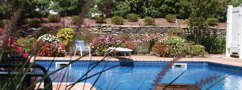 Pool with diving board surrounded by flowers