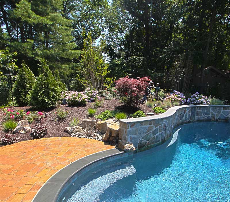 Pool with retaining wall and greenery surrounding